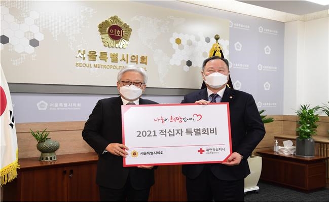 17일 서울시의회 김인호 의장(오른쪽)이 대한적십자사 서울특별지사에 적십자 희망성금을 전달하고 있다.