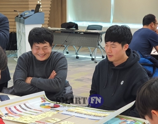 김선우(왼쪽·조장) 교육생이 자신들이 작성한 경영 장부를 보며 함박 웃음을 짓고 있다. 사진=임해정 기자. 