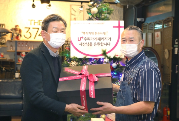 황현식 LG유플러스 사장(왼쪽)이 1차 캠페인을 통해 선정된 서울 강남구 소재 ‘THE 374’를 방문해 소상공인 사장님에게 선물을 증정하는 있다. /사진=LG유플러스