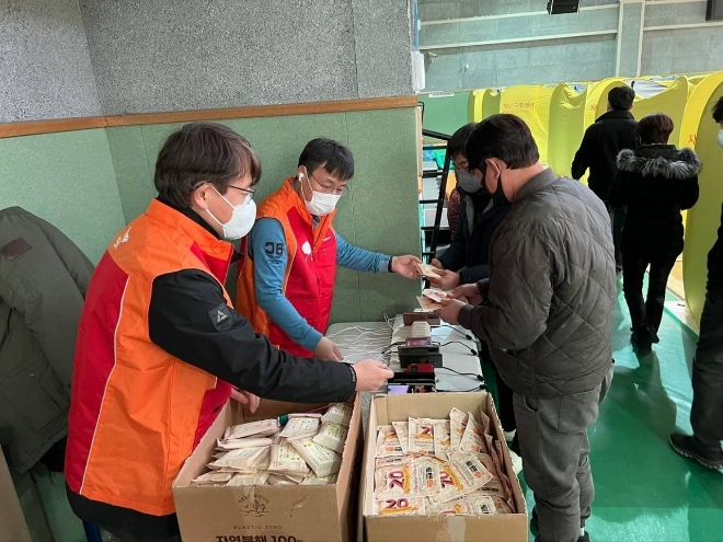 SK텔레콤 관계자들이 지난 5일 경북 울진 국민체육센터에 설치된 대피소에서 주민들에게 핫팩 등 생필품을 지원하고 있다. /사진=연합