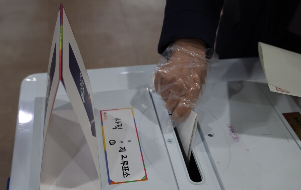 9일 종로구 사직동 투표소에서 코로나19 방역을 위해 비닐장갑을 낀 시민이 투표하고 있다. 사진=연합뉴스