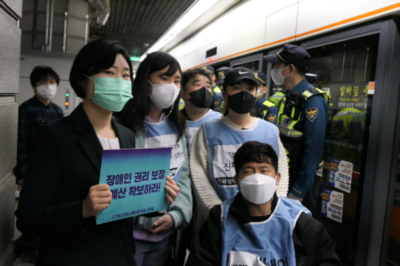 신지혜 기본소득당 서울시장 예비후보가 21일 피켓을 들고 장애인 단체의 지하철 시위에 함께하고 있다. / 사진=페이스북