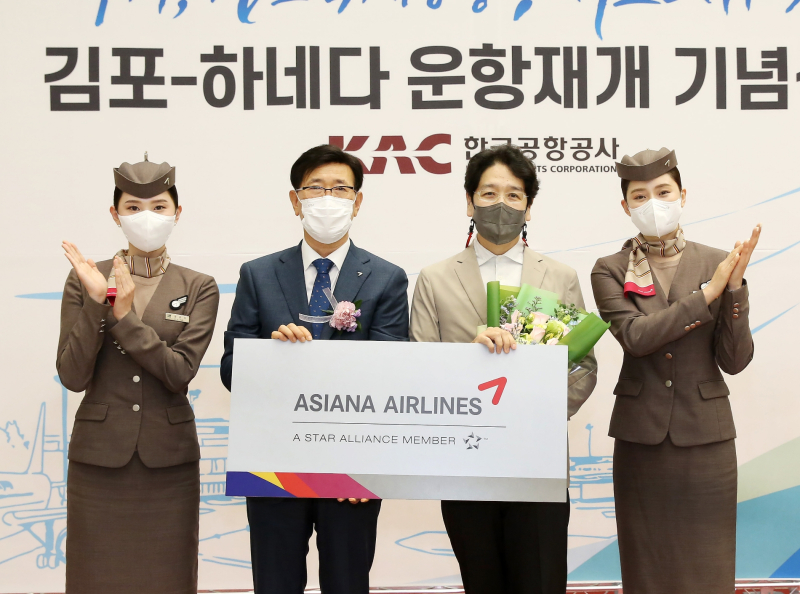 정성권 아시아나항공 대표(왼쪽 두번째)가 출발편 탑승객 1명에게 김포-하네다 노선 왕복 항공권을 증정한 후 기념 촬영을 하고 있다. /사진=아시아나항공