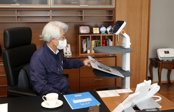 김태오 DGB금융그룹 회장에게 AI 로봇이 신문을 전달하고 있다. 사진=DGB금융그룹