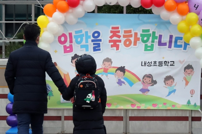 지난해 3월 2일 부산 동래구 내성초등학교에서 입학생이 학부모의 손을 잡고 입학식 포토존 앞으로 걸어가는 모습./이미지=연합뉴스