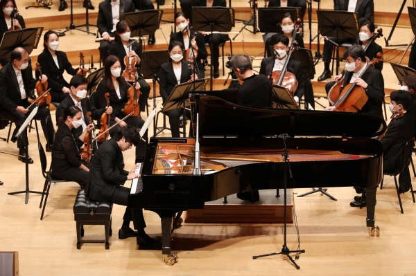 23일 서울 롯데콘서트홀에서 열린 교보 노블리에 콘서트에서 피아니스트 임윤찬이 마에스트로 정명훈(가운데)이 지휘하는 KBS교향악단과 협연하고 있다.