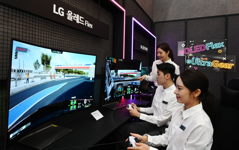 LG전자 모델들이 서울 삼성동 코엑스에서 열리는 한국전자전(KES 2022)에서 벤더블(Bendable) 게이밍 올레드 TV 플렉스(FLEX)로 게임을 즐기고 있다. /사진=LG전자